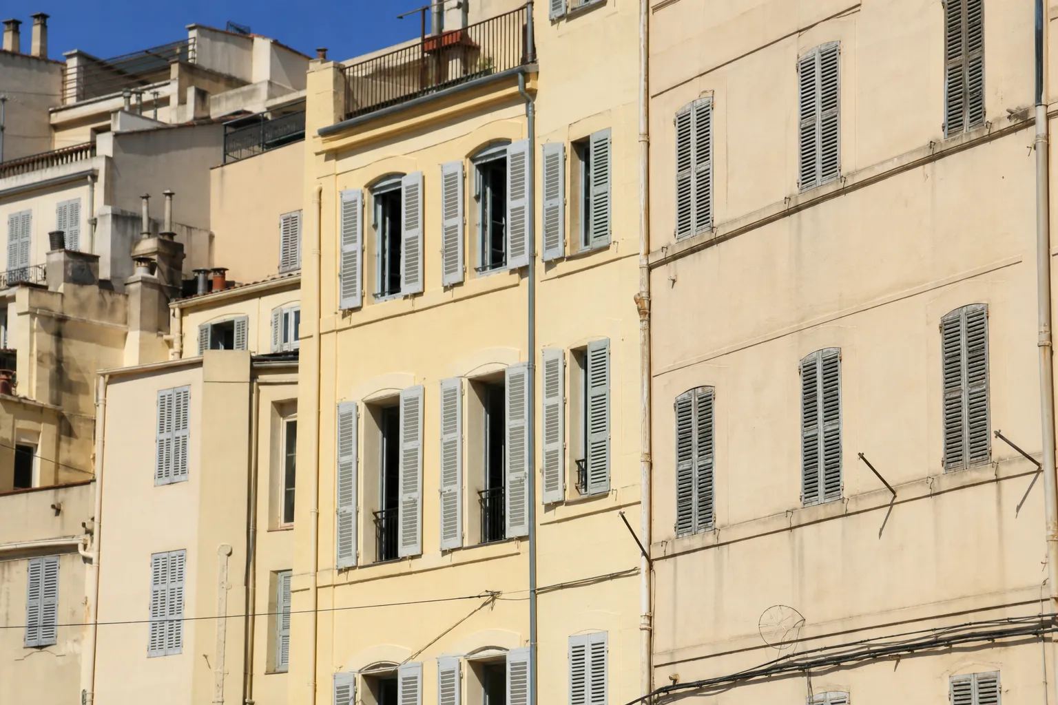 Façade d’un immeuble urbain aux tons clairs et ocres, architecture méditerranéenne dense