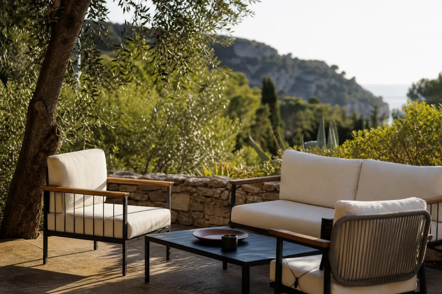 Terrasse extérieure baignée d’une lumière méditerranéenne franche en fin d’après-midi